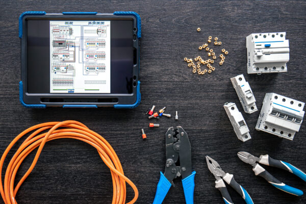 Flat lay composition with electrical tools and digital tablet on wooden background.