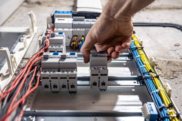 Voltage switchboard with circuit breakers are in the ON and OF positions in the big electric box for electrical distribution panel, and temporary electric cables are switched.